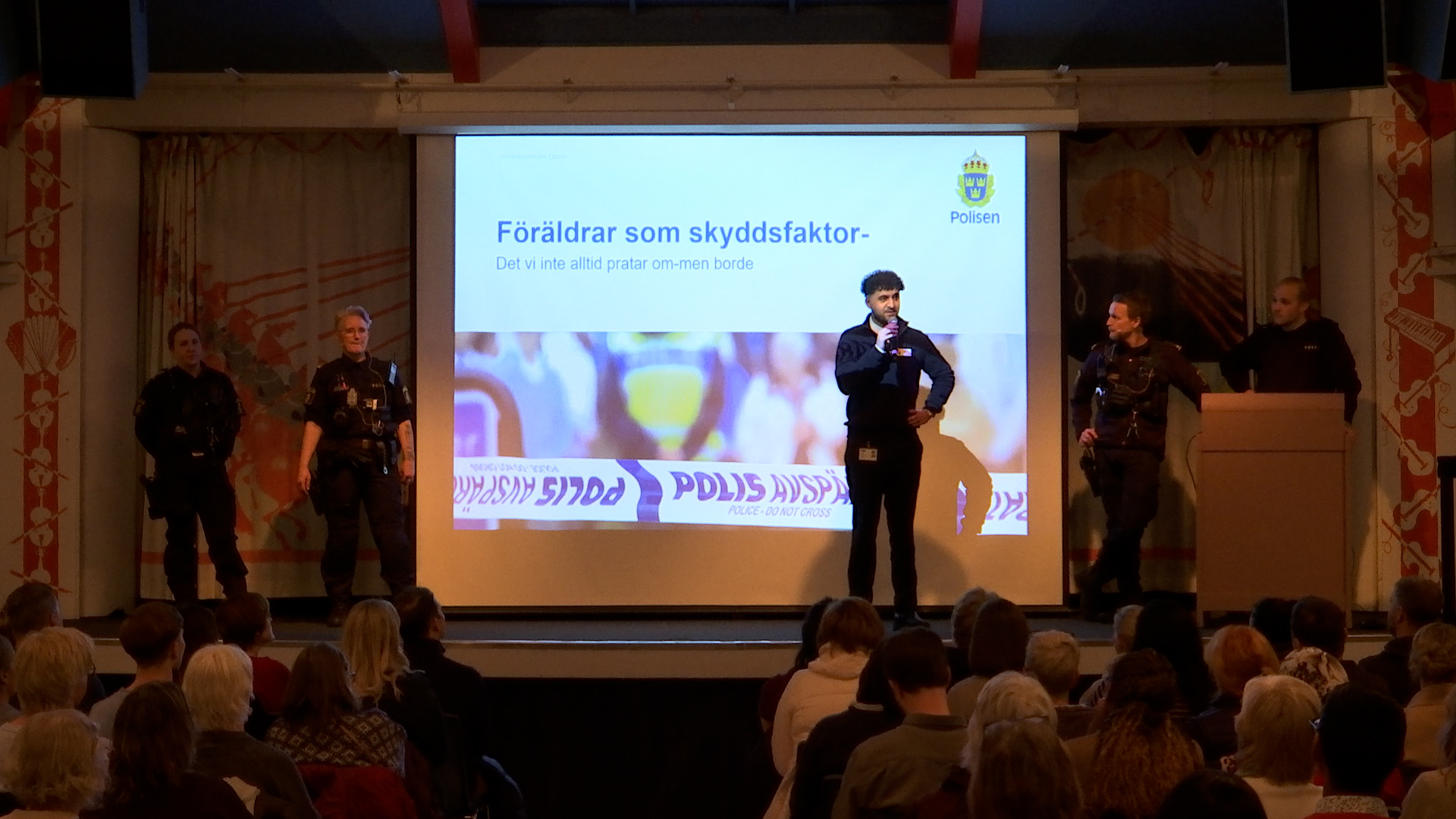 polisen och Sherwan på scenen.