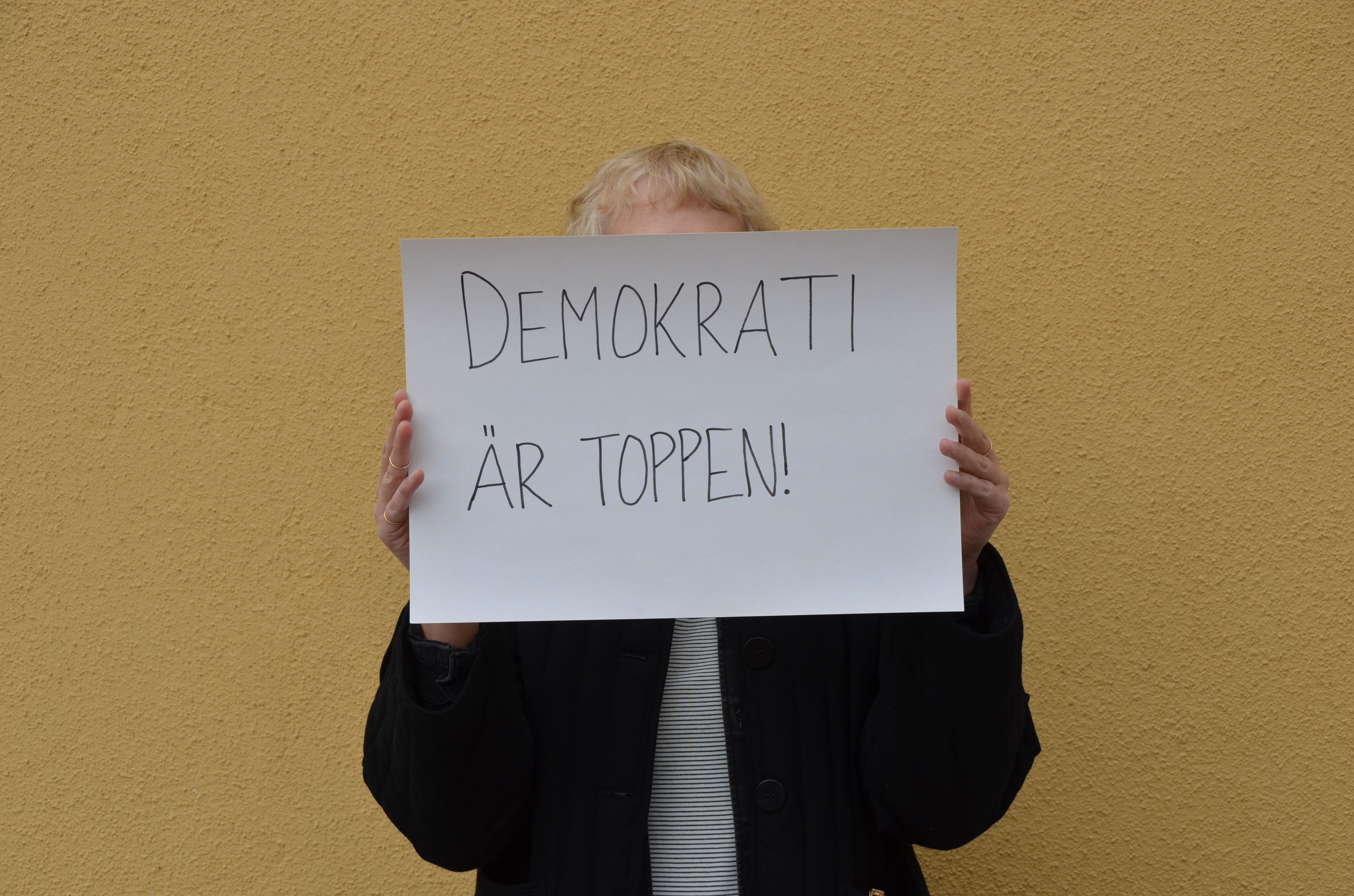 Person som håller upp skylt Demokrati är toppen