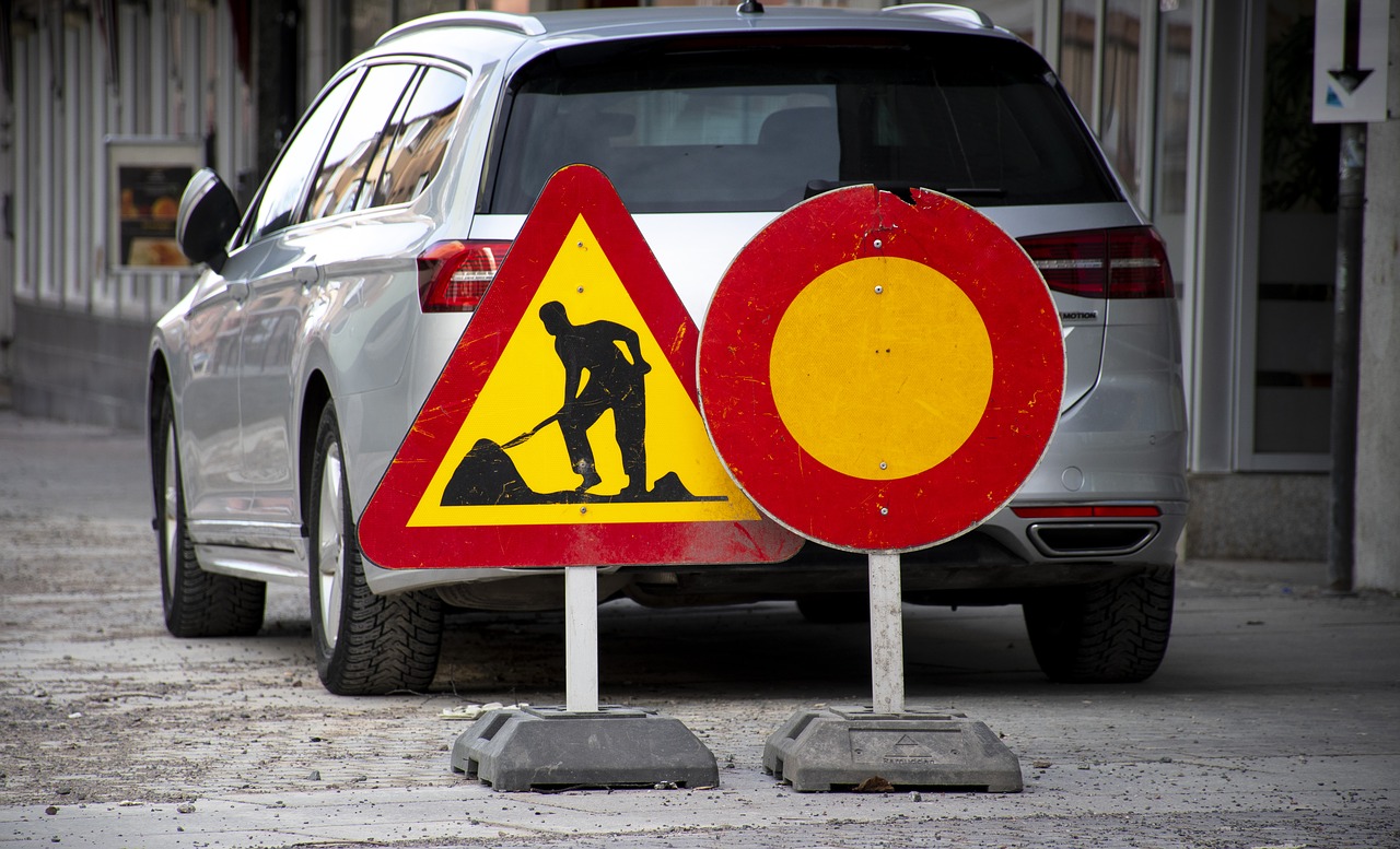 Skylt för vägbygge framför bil som står parkerad på gata