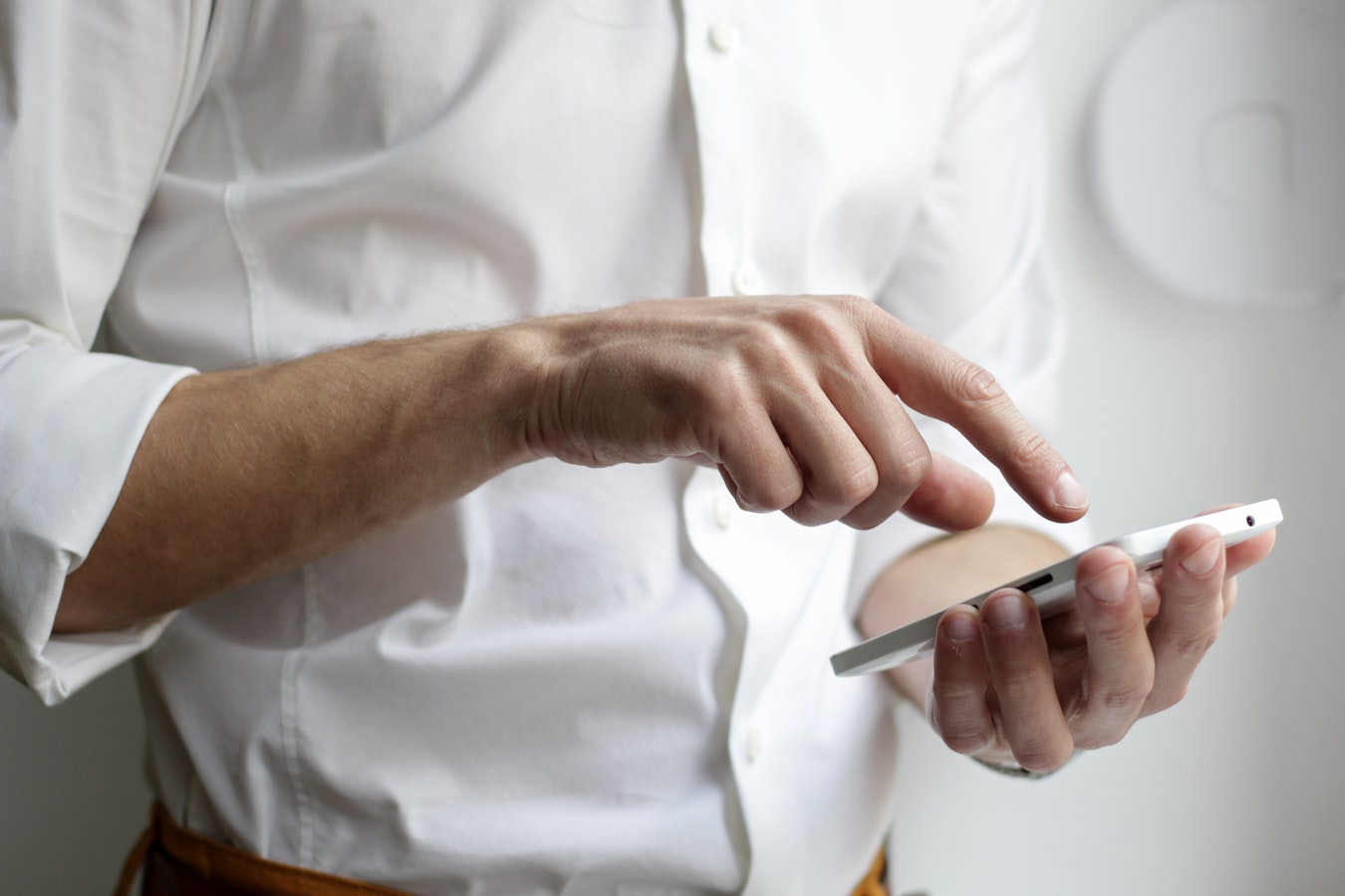 Man som pekar på mobiltelefonens skärm