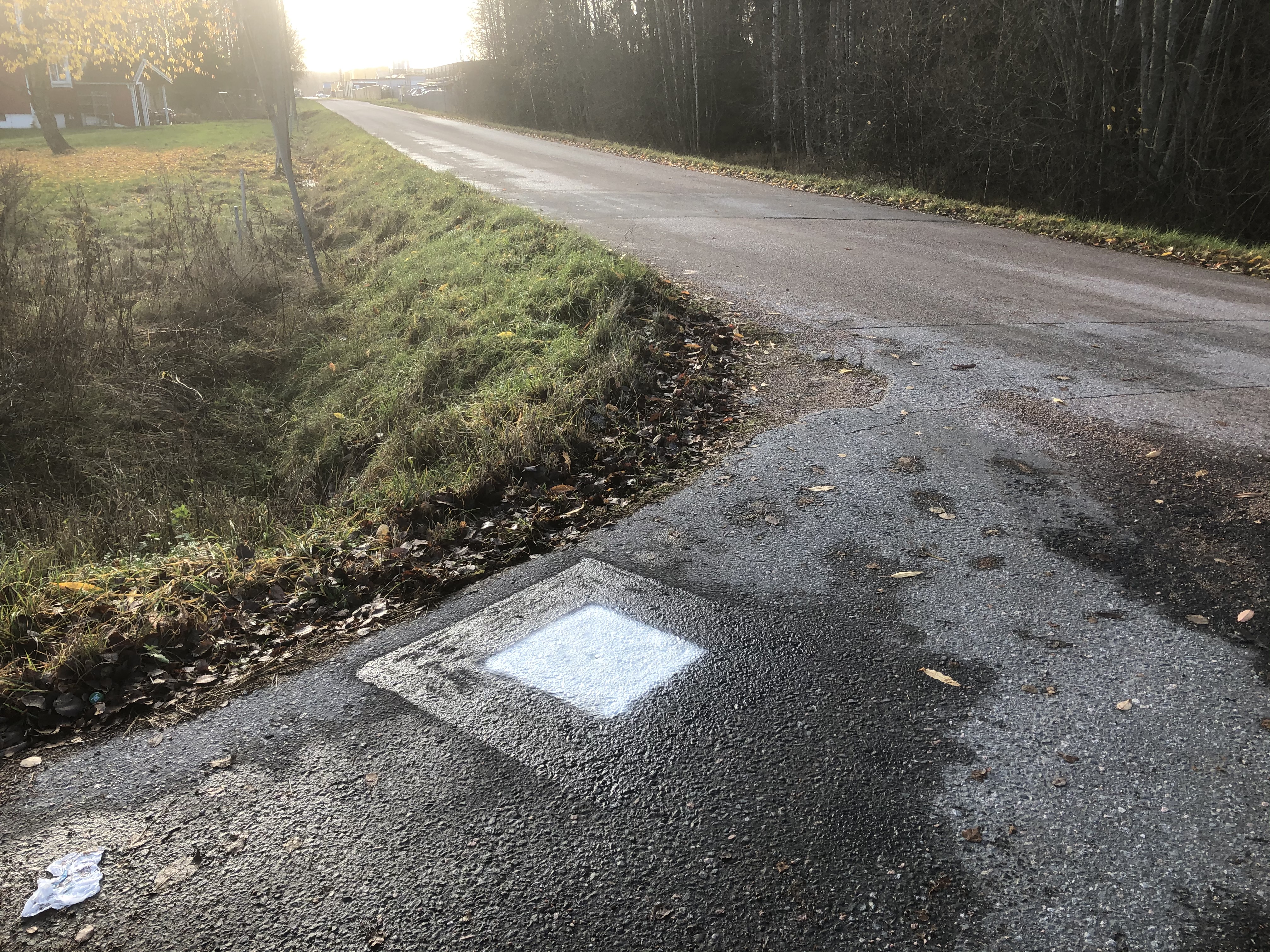 Markering på asfalten med hus i bakgrunden