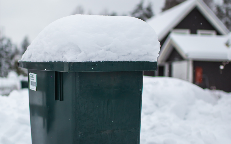 Snötäckt sopkärl.
