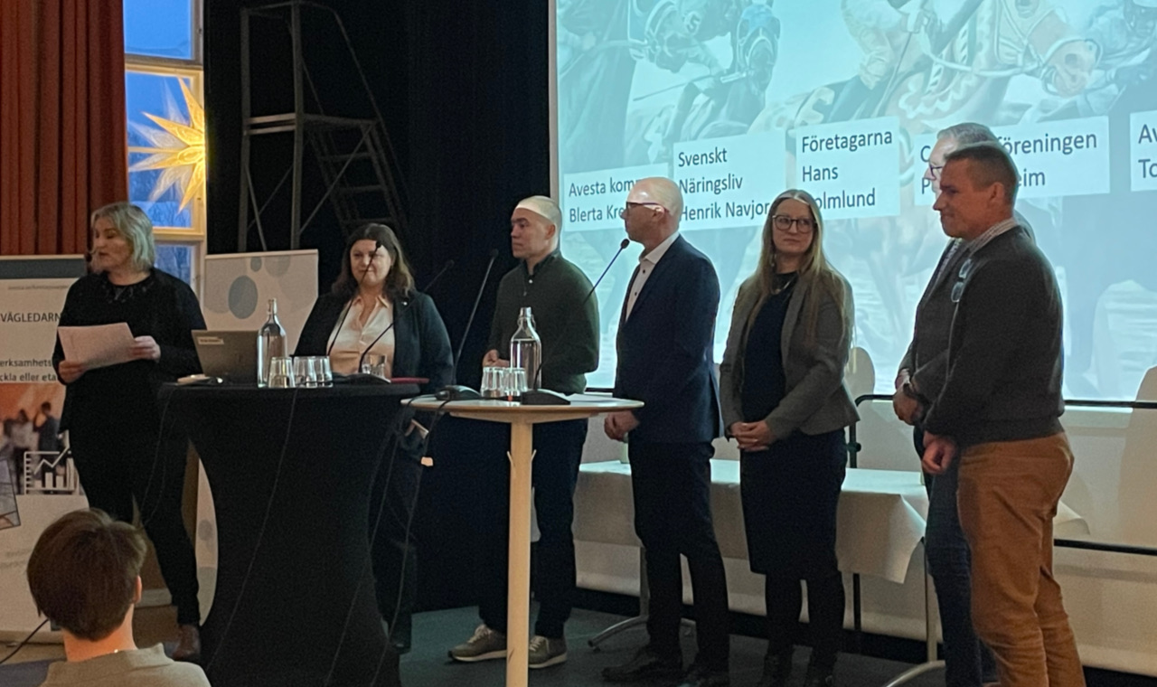 Personer som står på en scen och pratar