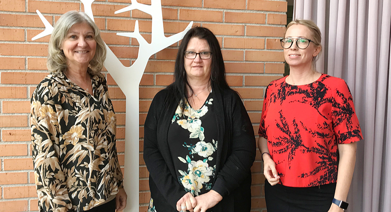 Tre kvinnliga s k lotsar framför en vägg.
