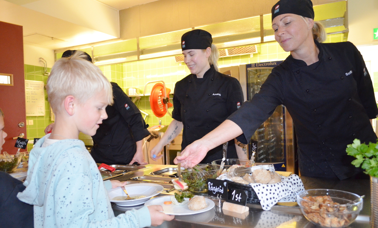 pojke tar emot mat i skolmatsalen