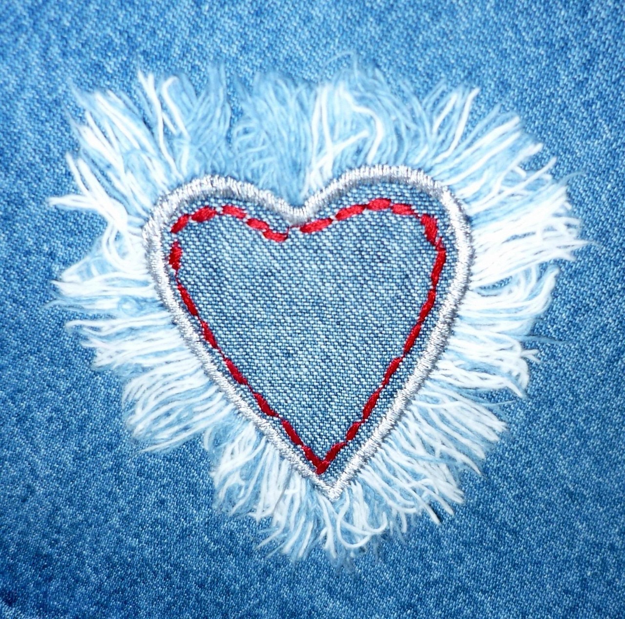 Ett textilhjärta sytt på jeans.