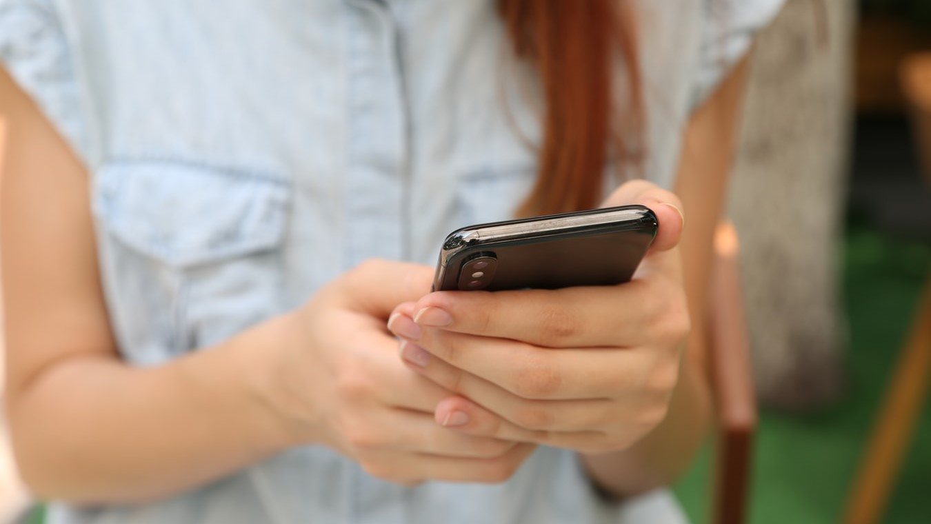 Tjej håller i smartphone, redo att felanmäla