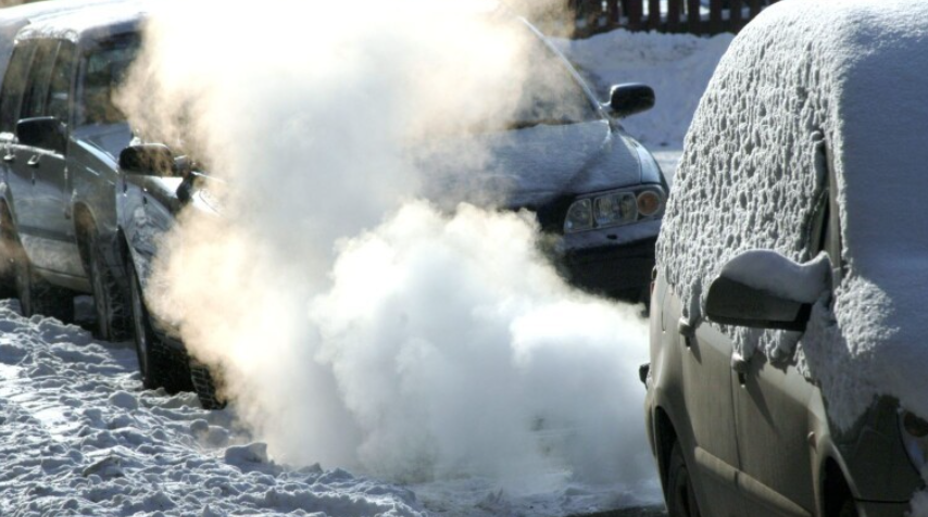 Bilar i vintermiljö som har motorn igång