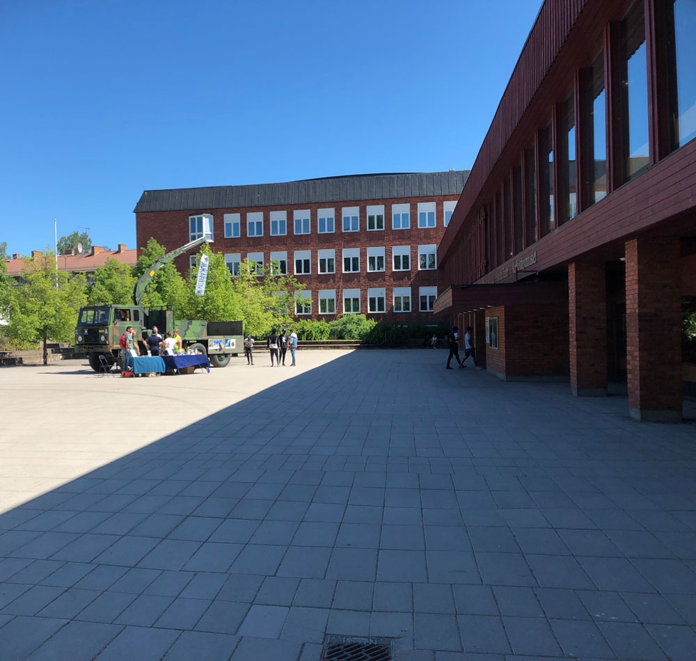 Frivilliga bilkåren informerar om krisberedskap på Karlfeldtgymnasiet. Ett stort terängfordon på skolgården med informationsbord och några ungdomar som lyssnar och ställer frågor.