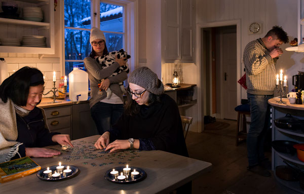 Familj i sitt hus upplyst av stearinljus under ett strömavbrott, foto: Thomas Henrikson MSB