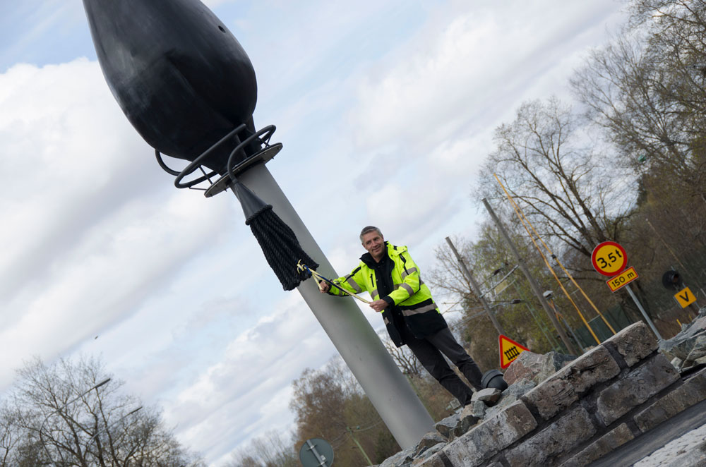 Lars Isacsson, kommunstyrelsens ordförande klipper bandet på cirkulationsplatsens utsmyckning.