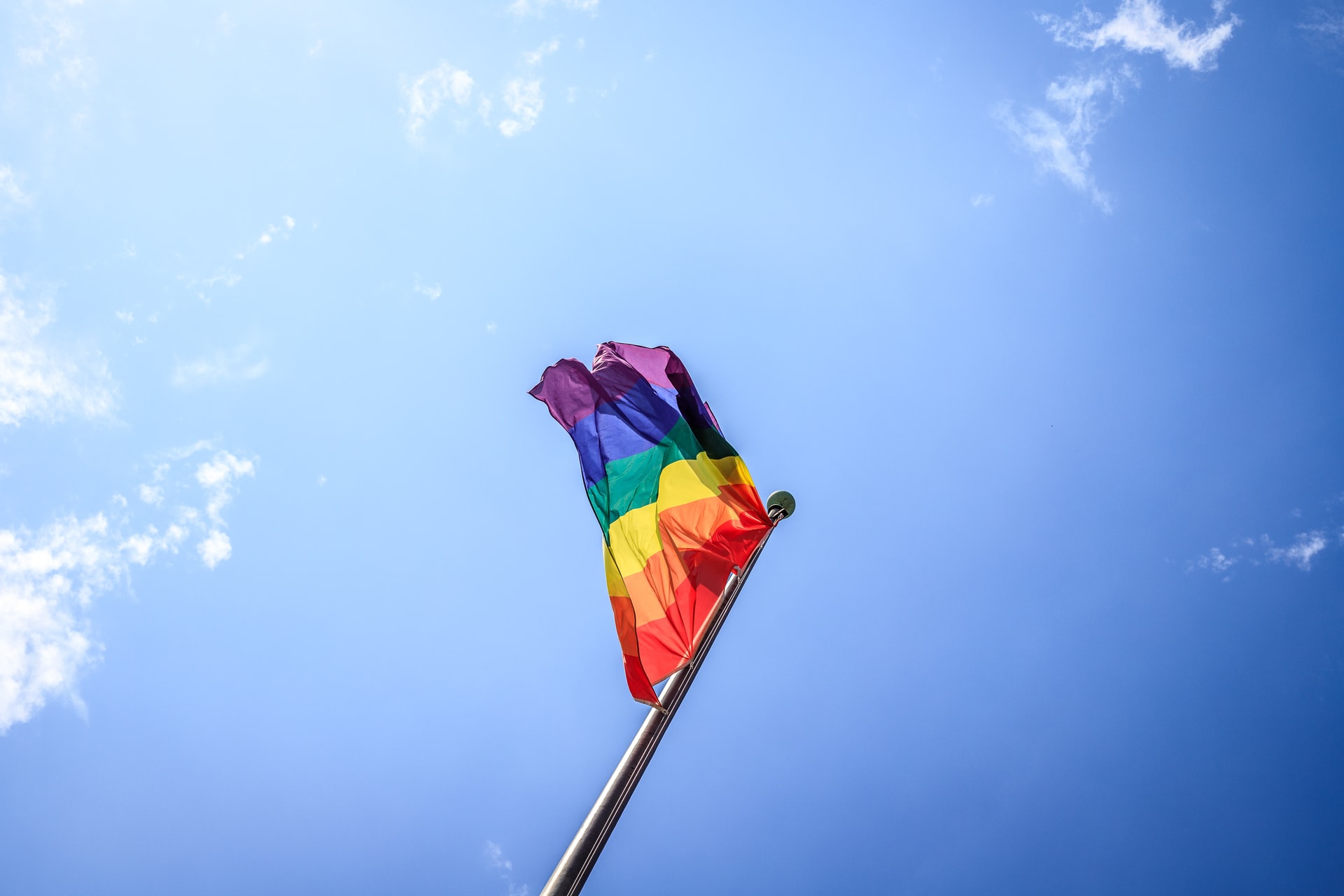 regnbågsfärgad flagga mot blå himmel
